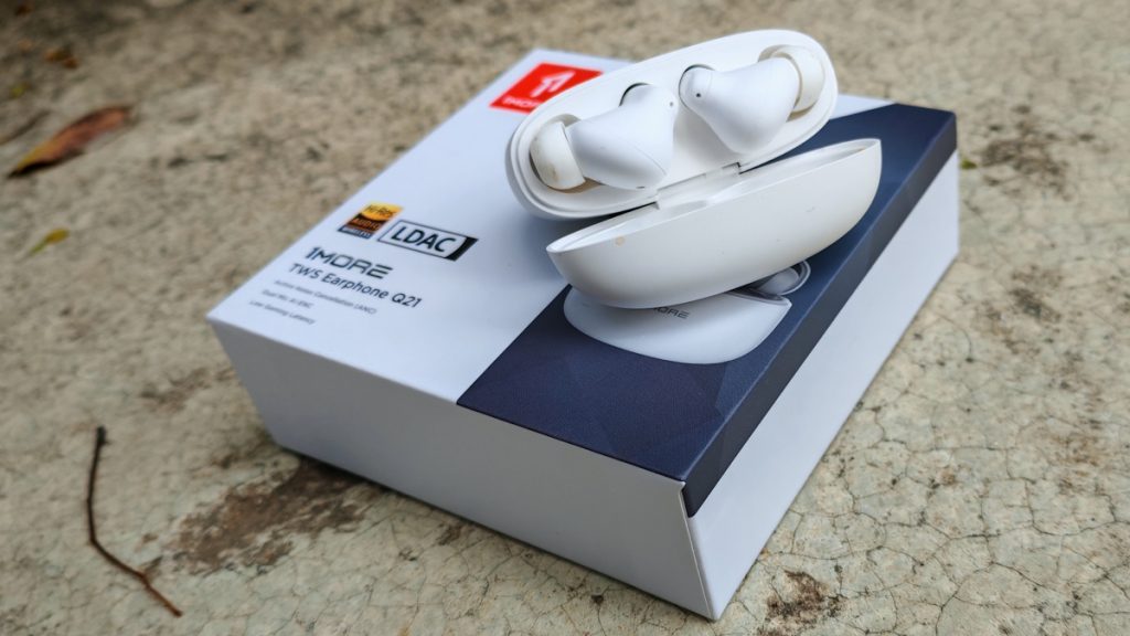 1More TWS Earphone Q21 שתיהן בתוך המארז כשהוא פתוח ומעל הקופסה ששוכבת